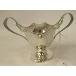 An Edwardian silver bead and reel bordered sauce boat of oval form with twin loop handles and