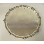 A late Victorian silver tray with a raised gadrooned, scrolled and bellflower cast border and a