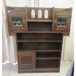 An early 20thC Liberty & Co stained, planked oak, open front cabinet with stylised spot-hammered,