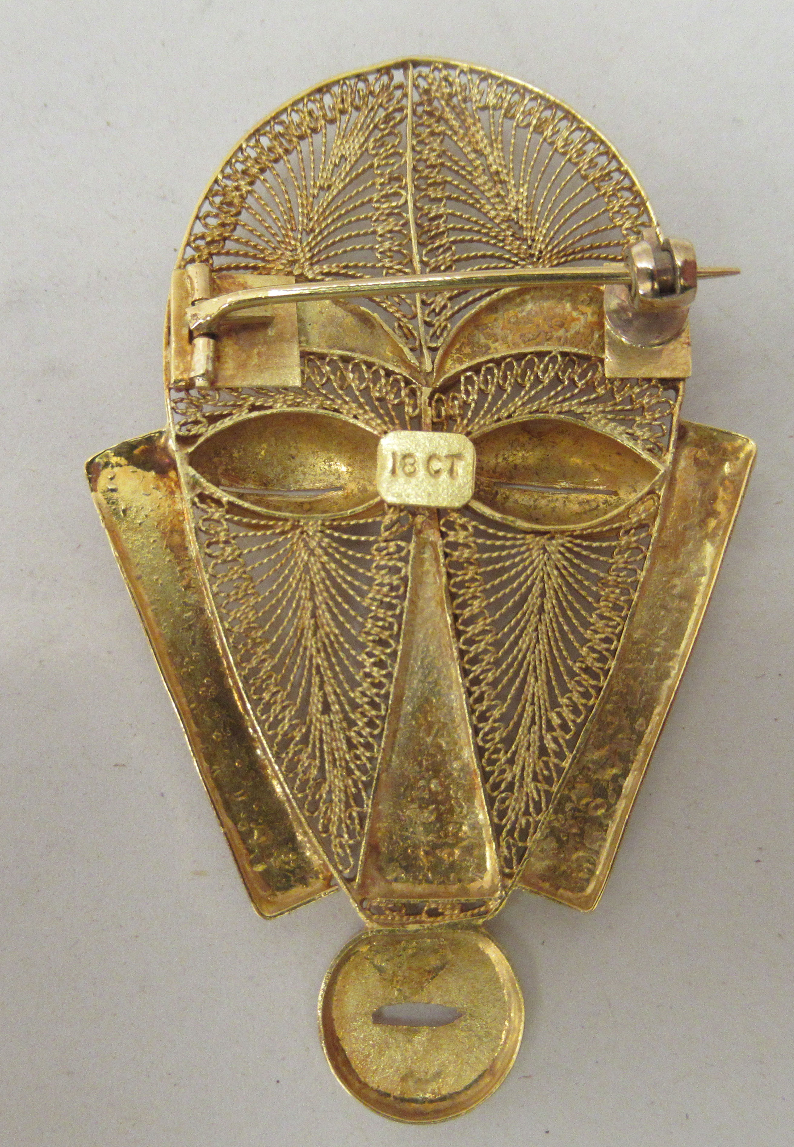 An African gold brooch, fashioned as a tribal mask with filigree ornament  stamped 18ct - Image 2 of 2