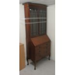 An early/mid 20thC mahogany bureau bookcase, the twin door upper glazed section over three graduated