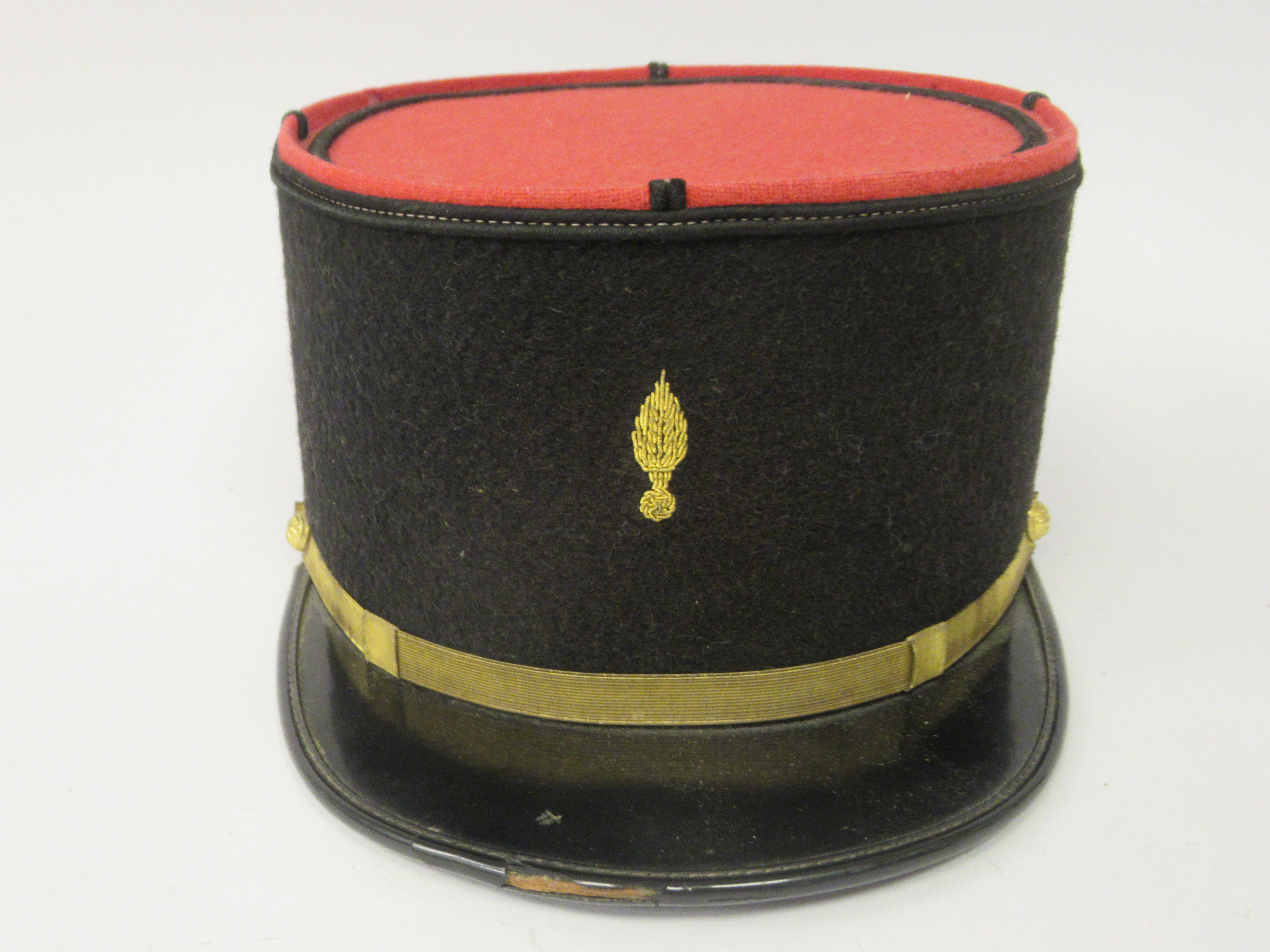 A vintage French Gendarme's black and red, peaked kepi