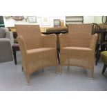A pair of modern cane line enclosed arm simulated wicker chairs