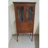 An Edwardian crossbanded, string and ebony inlaid mahogany music cabinet with a pair of glazed