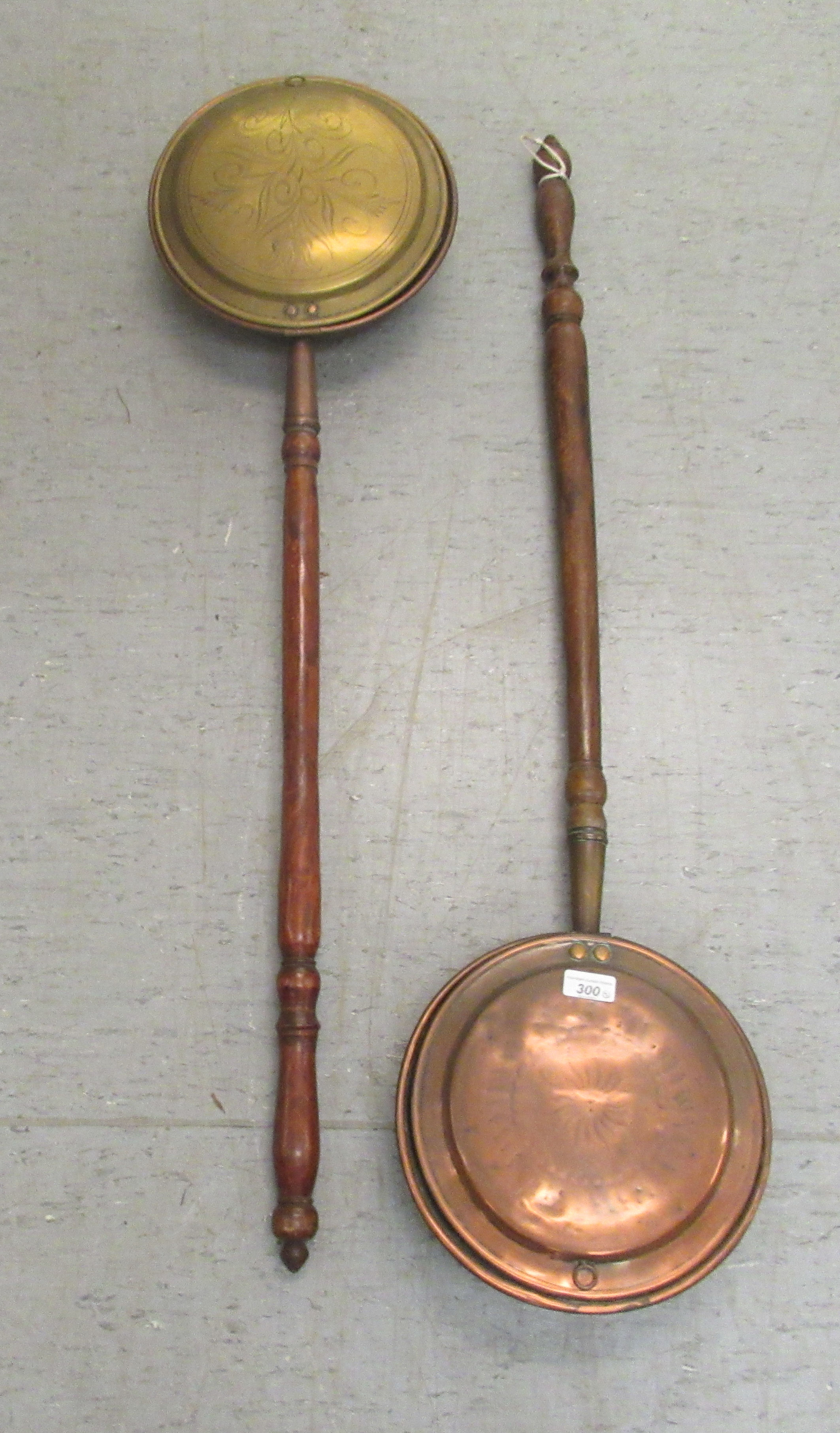 An early 19thC copper and brass warming pan with a scratch engraved design on the lid, on a turned