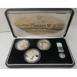 A Royal Mint Crimean War silver proof three coin £5 set with a miniature replica medal