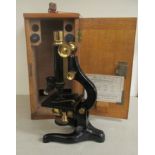 A D Watson & Sons lacquered black enamel and brass microscope with three rotating lenses, in a