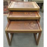 A nesting set of three modern teak framed tile top occasional tables, raised on block legs