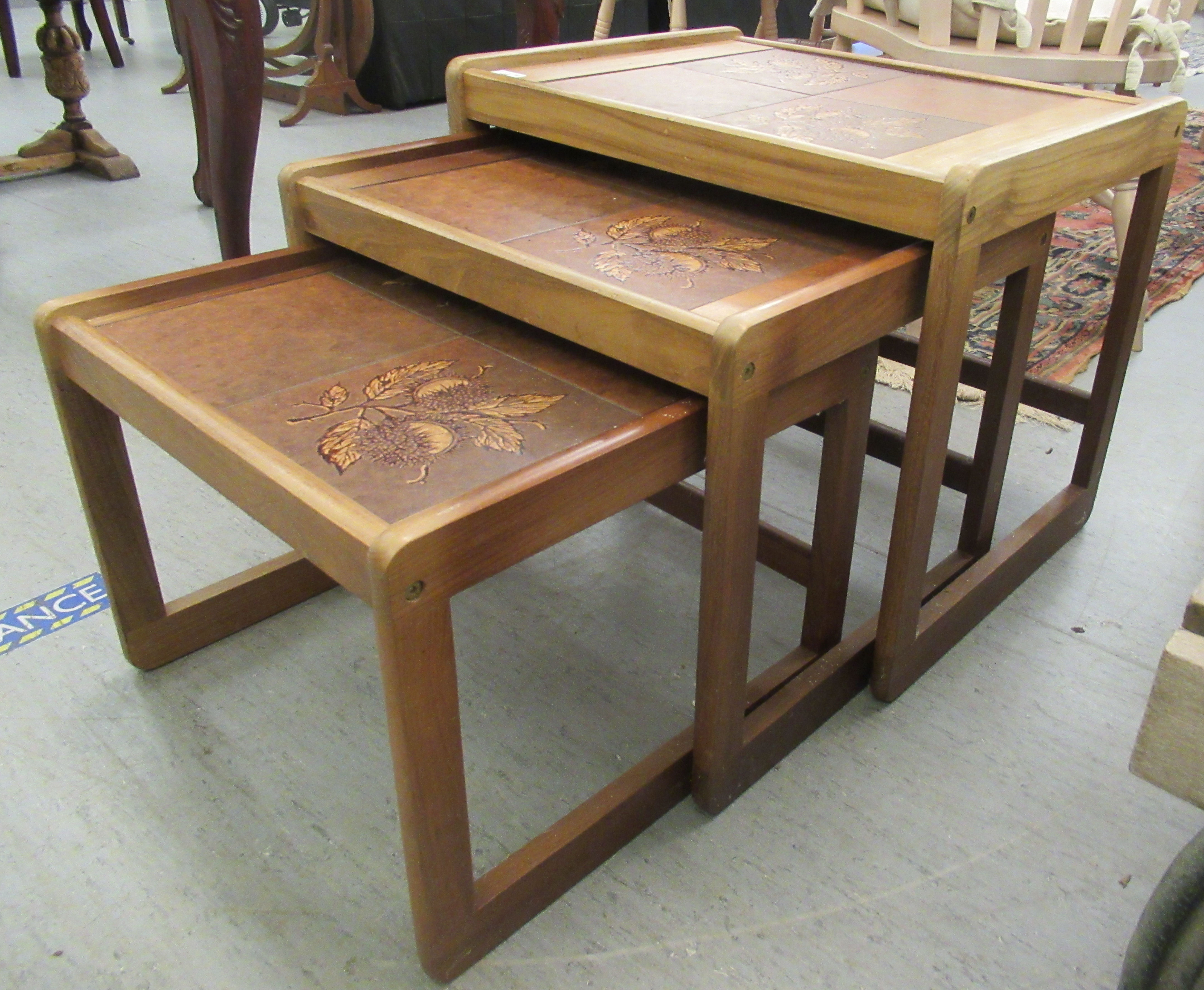 A nesting set of three modern teak framed tile top occasional tables, raised on block legs - Image 2 of 3