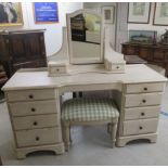 A modern Ducal cream washed painted pine dressing table, comprising a dressing mirror over nine