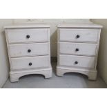 A pair of modern Ducal cream washed painted pine, three drawer dressing chests, on plinths and