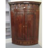 A George III satinwood inlaid mahogany hanging corner cabinet with two panelled doors and a base