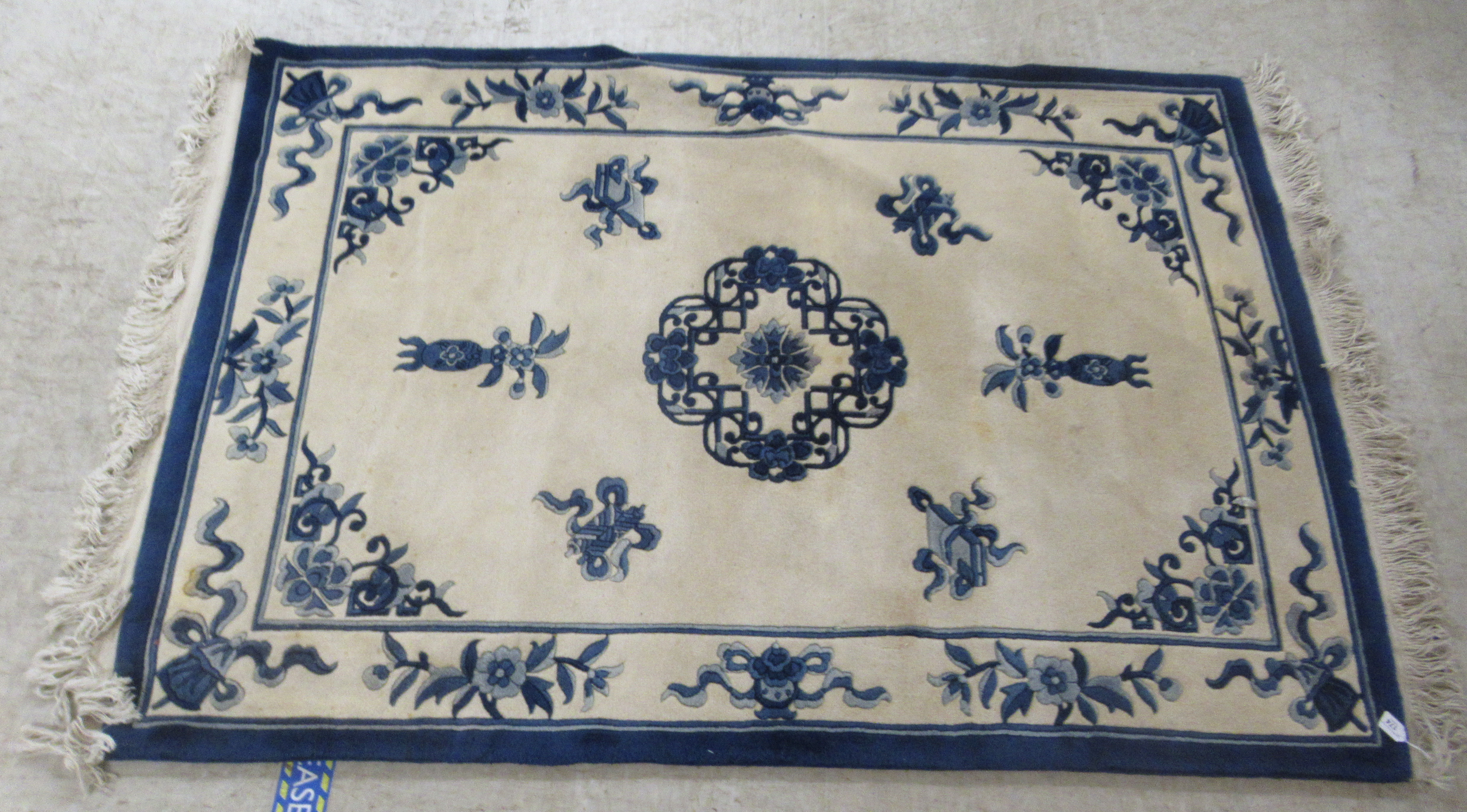 A modern Chinese washed woollen rug, traditionally decorated on a blue and white ground  48" x 76"