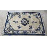 A modern Chinese washed woollen rug, traditionally decorated on a blue and white ground  48" x 76"