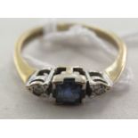 A 9ct gold ring, set with a central sapphire, flanked by two diamonds