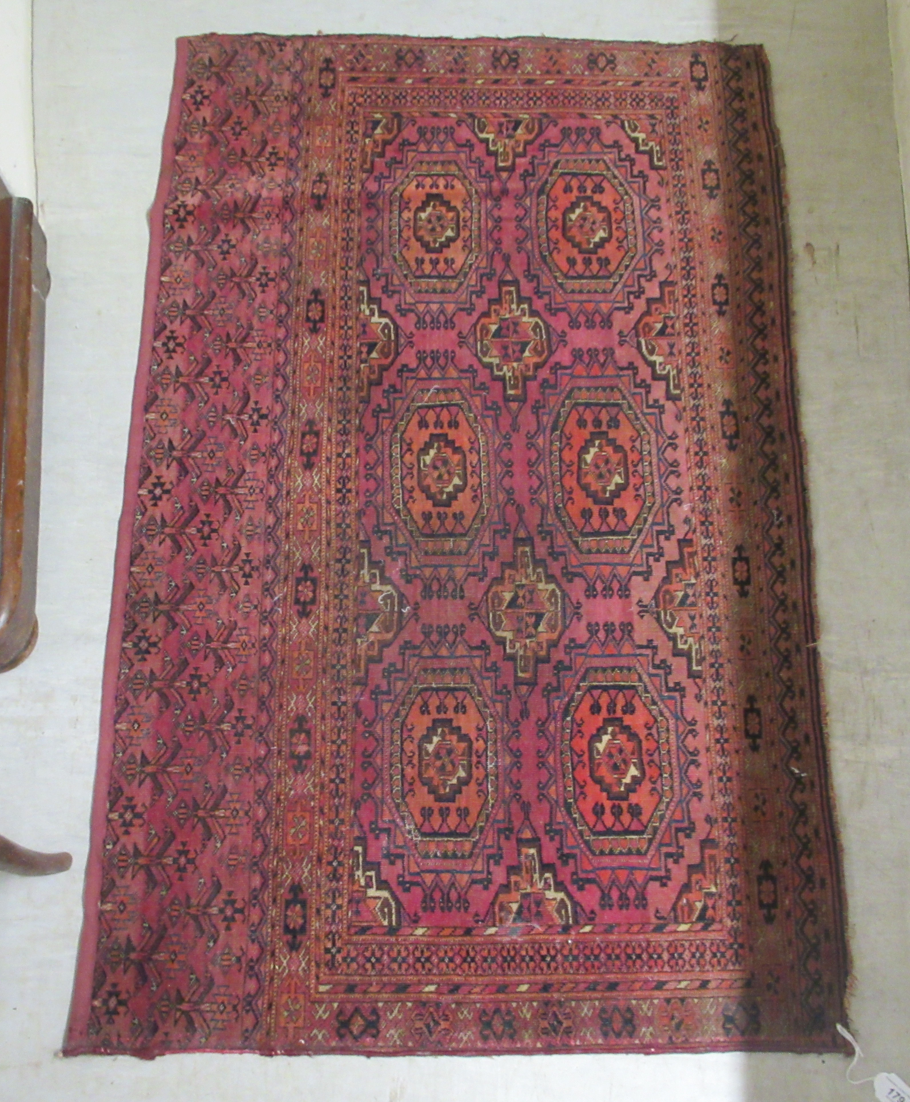 A Bokhara rug, decorated with two columns of four octagonal motifs, on a red ground  29" x 47"