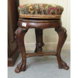 A late 19thC Continental walnut framed revolving music stool, raised on cabriole legs and lion paw