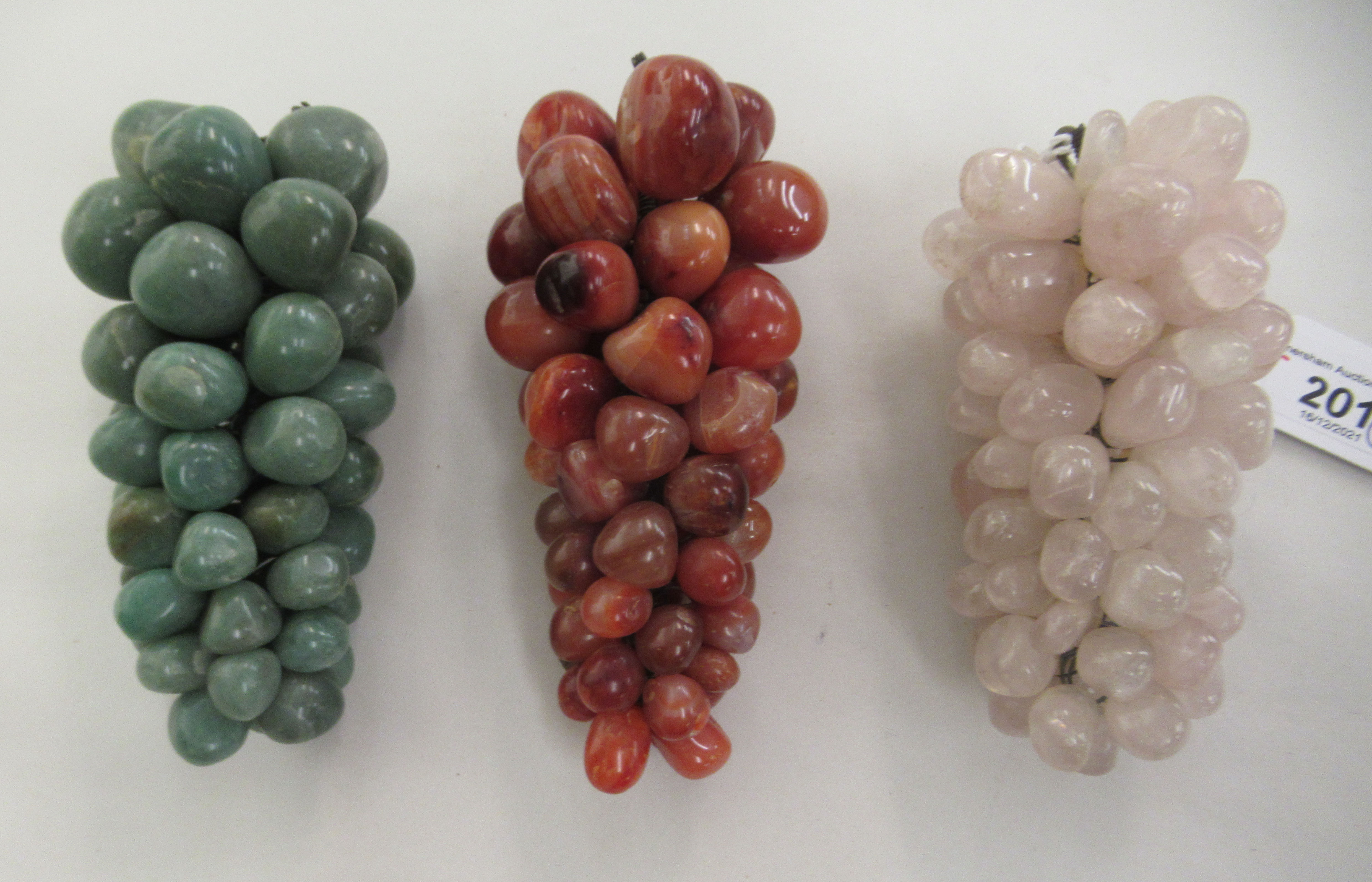 Three coloured hardstone ornaments, each fashioned as a bunch of grapes  6" - 8"h