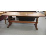 A modern light oak refectory table, the top with bow front edges, raised on opposing vase shaped