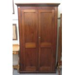 An Edwardian mahogany wardrobe with a moulded cornice, over two full height panelled doors, on a