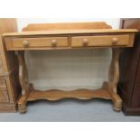 A late Victorian stained pine washstand, the top with a low upstand, over two frieze drawers, raised