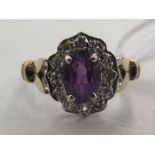 A 9ct gold cluster ring, set with a central purple coloured stone, surrounded by diamonds