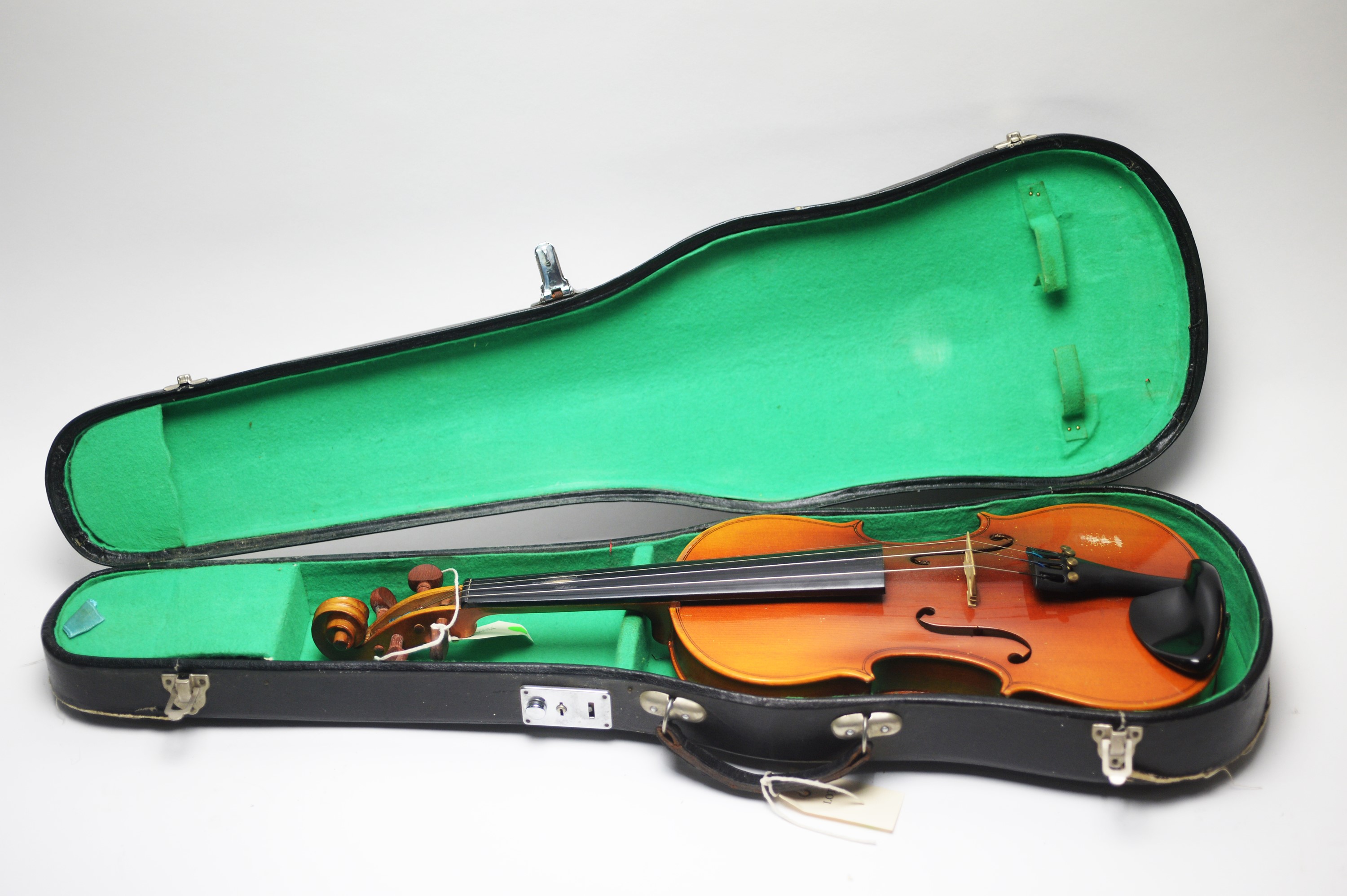 Four student violins and a bow, all cased.