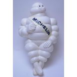 A plastic vintage Michelin Man figure on stand.