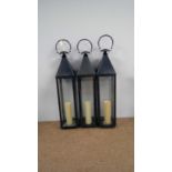 Three patinated metal lanterns.