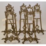 Five brass easel stands.