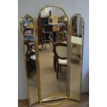 A modern brass full-length mirror.