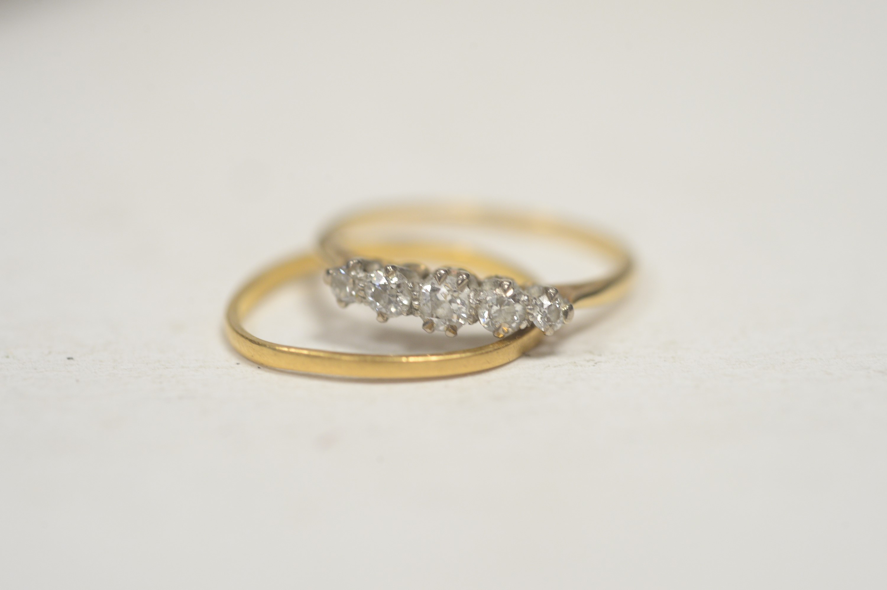 A five stone diamond ring; and a wedding band.