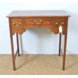 A Georgian mahogany lowboy, with rectangular moulded top above three drawers, shaped apron, on