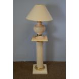 A marble effect pedestal and table lamp