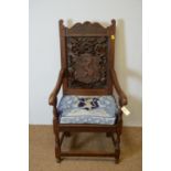 Ceremonial-style carved oak open arm chair with crest and motto.