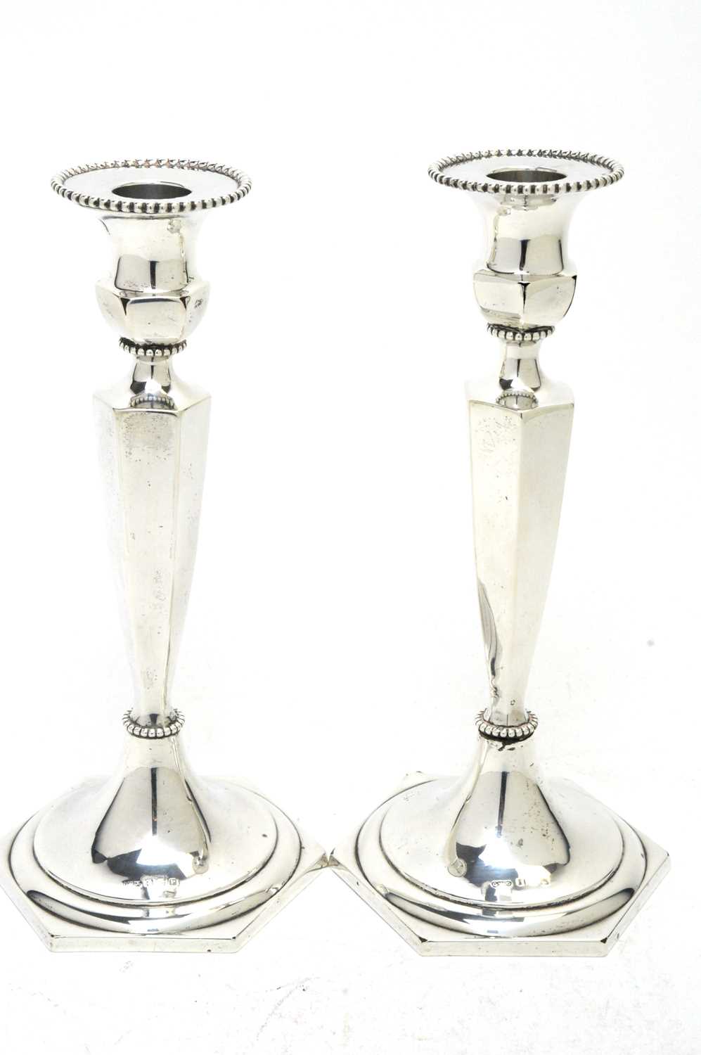 A pair of DLI interest silver candlesticks