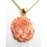A carved coral pendant on 18ct gold chain