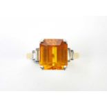 An orange sapphire and diamond ring