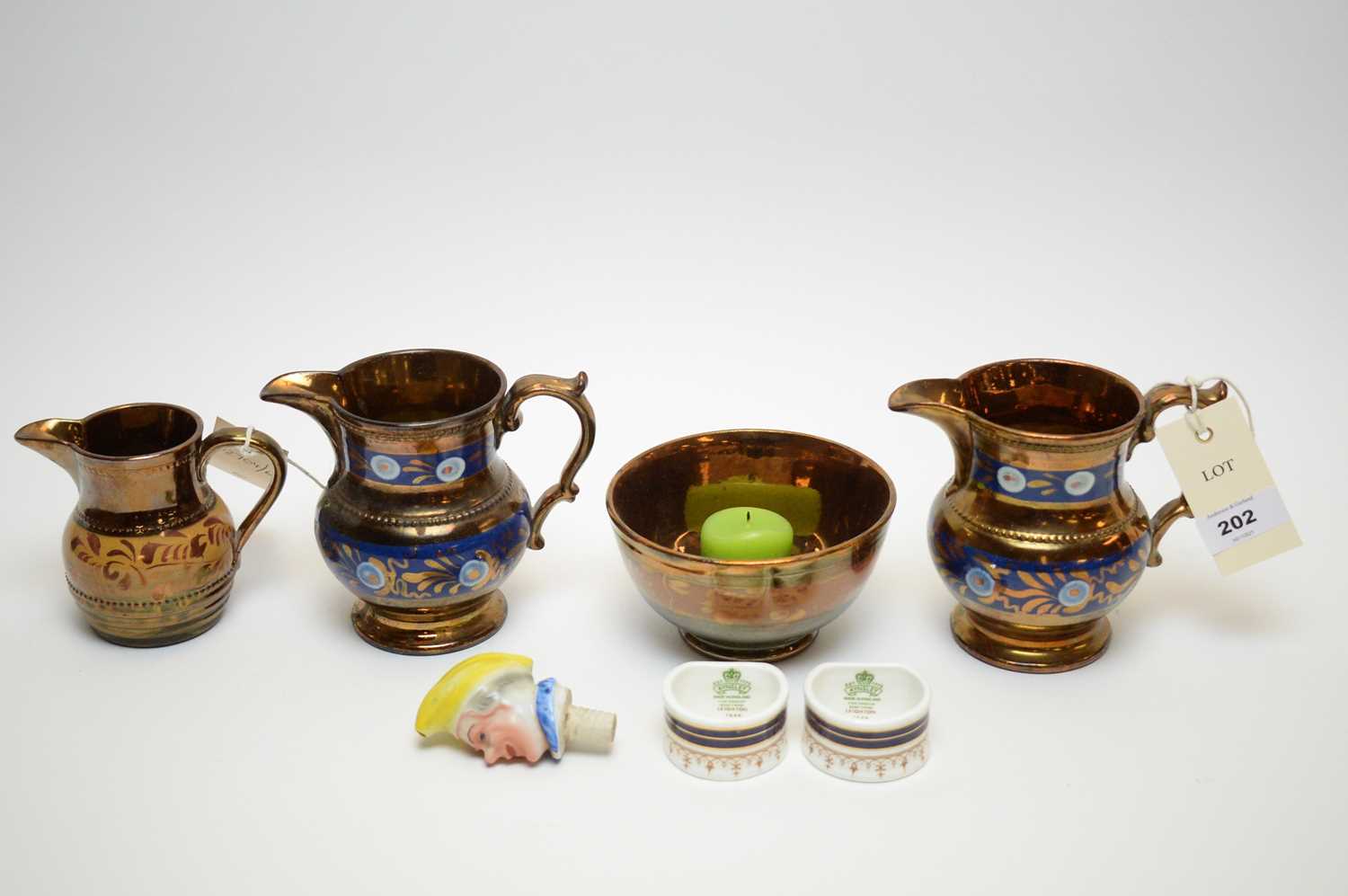 Three copper lustre jugs, the pair with blue band decoration, and another, a sugar bowl; a pair of