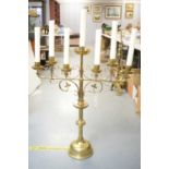 A large brass ecclesiastical Gothic candlestick, with seven sconces, on scrolling base and heavy