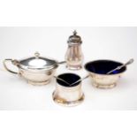 Three-piece silver condiment set and associated salt spoons.
