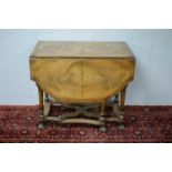 An early 20th Century Queen Anne style walnut drop leaf dining table