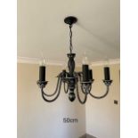 Three black painted metal chandeliers.