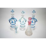 Four glass decanters; and a similar glass.