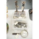Pair of silver plated candlesticks, silver plated cutlery and a magnifying glass.