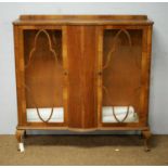 An early 20th Century walnut bow fronted display cabinet