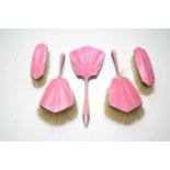 A pink enamel silver backed dressing table set