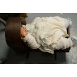 An Armand Marseille doll along with another in a cradle