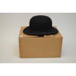 A selection of three black bowler hats and one brown bowler hat