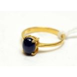 A high carat yellow-metal and sapphire cabochon dress ring.